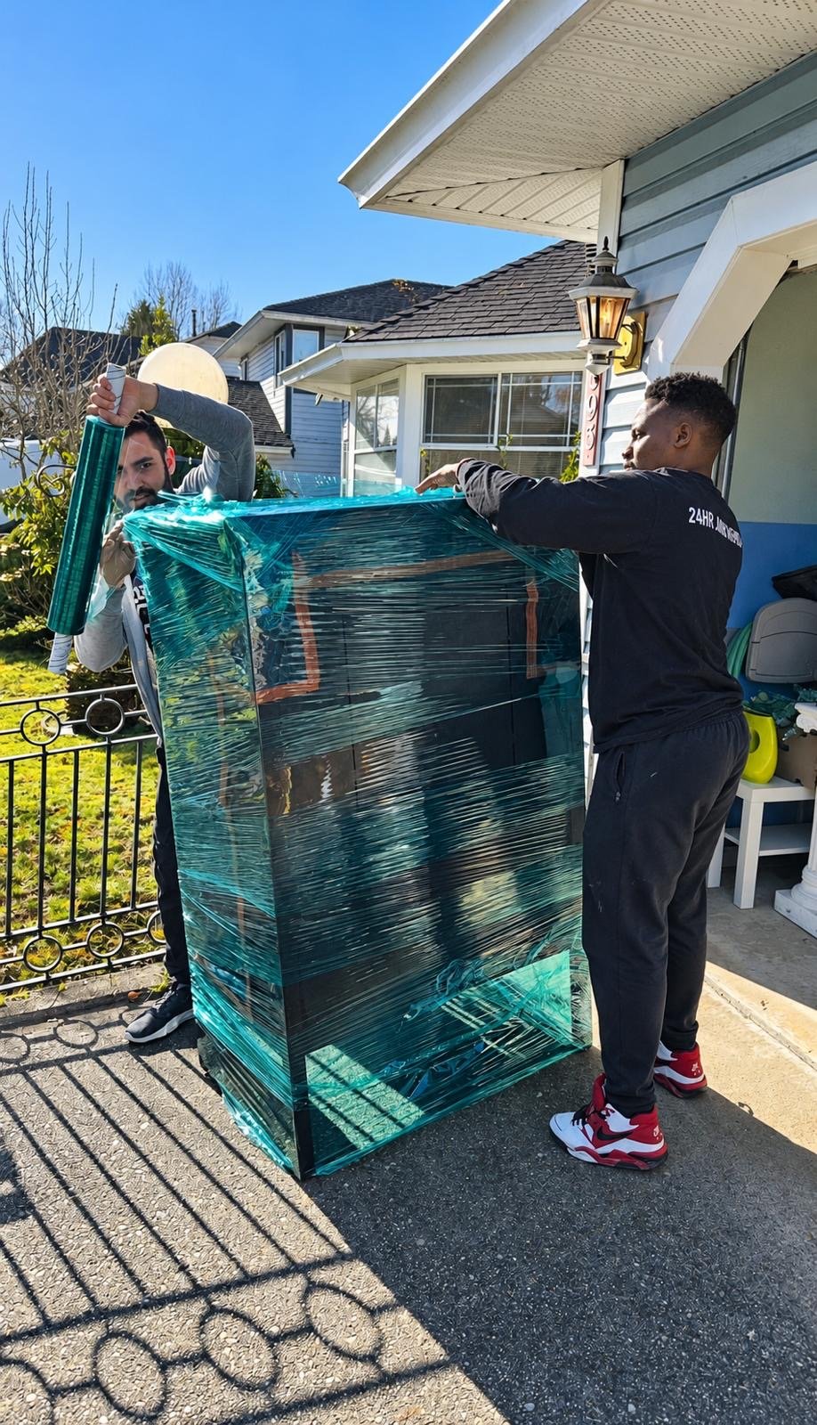 Movers wrapping furniture